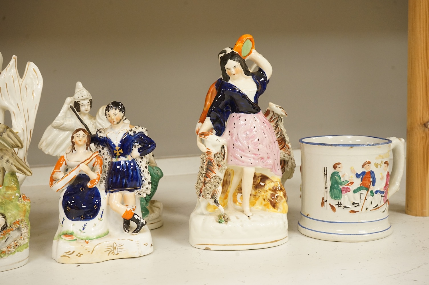 A collection of Staffordshire figures, mostly flatback to include a pocket watch holder, largest 37cm high